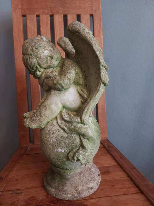 Stenen putto op bol